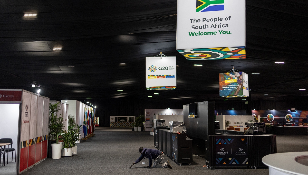 Un ouvrier repositionne un tapis au Nasrec Expo Centre, avant le sommet des dirigeants du G20, à Johannesburg, le 18 novembre 2025.