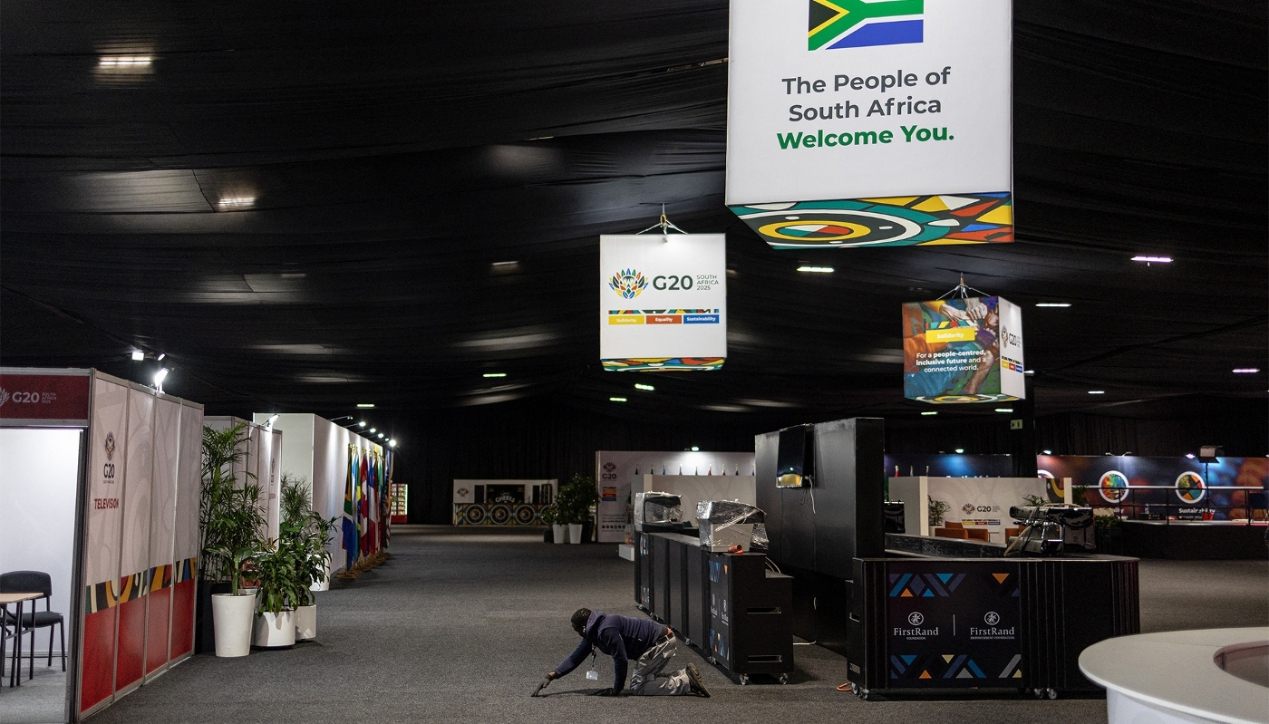 Un ouvrier repositionne un tapis au Nasrec Expo Centre, avant le sommet des dirigeants du G20, à Johannesburg, le 18 novembre 2025.