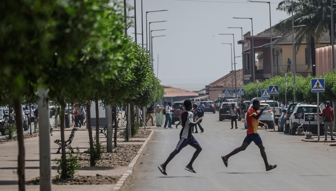 Des hommes s'enfuient alors que des coups de feu retentissent près du palais présidentiel à Bissau, le 26 novembre 2025.