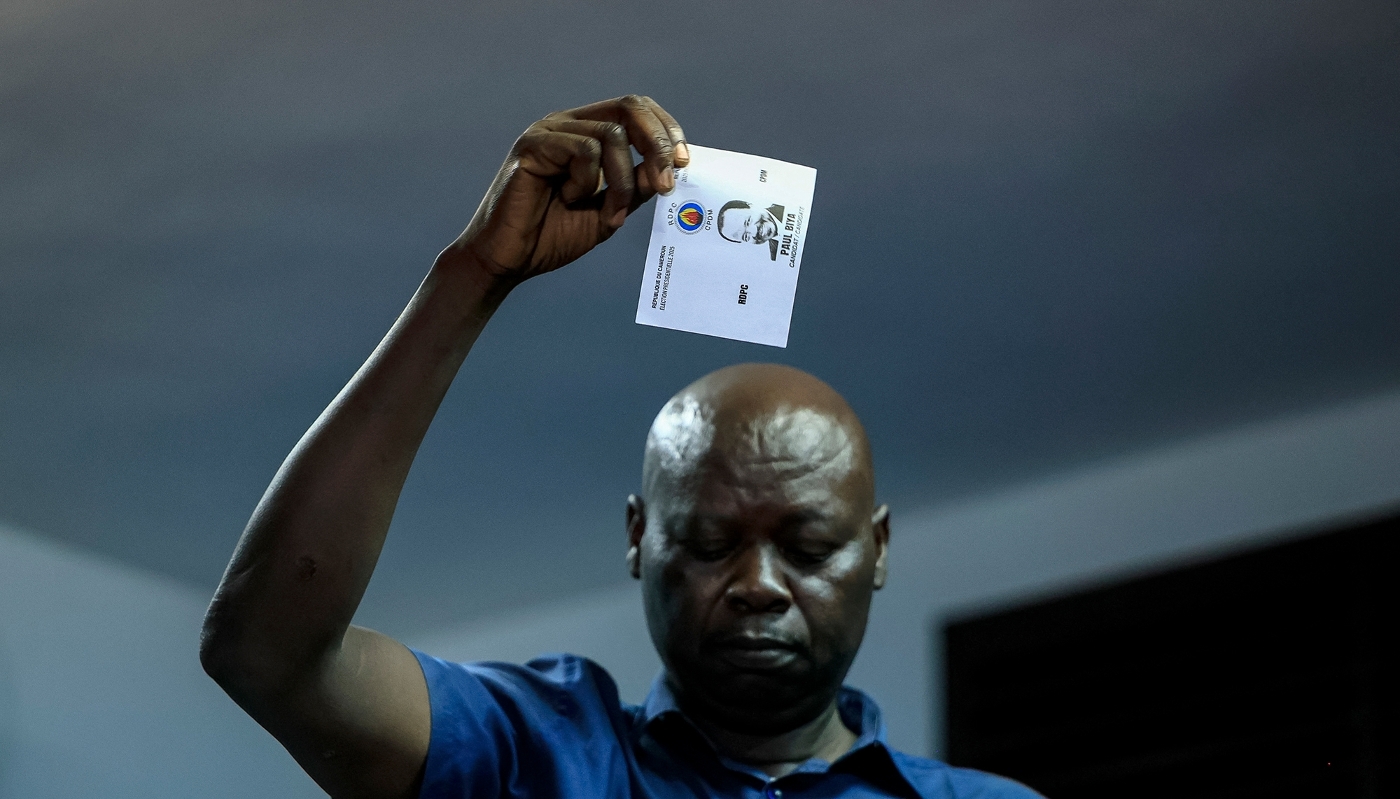 Un membre d'Elecam montre un bulletin de vote à l'effigie de Paul Biya lors du comptage des voix dans un bureau de vote de Yaoundé, le 12 octobre 2025.