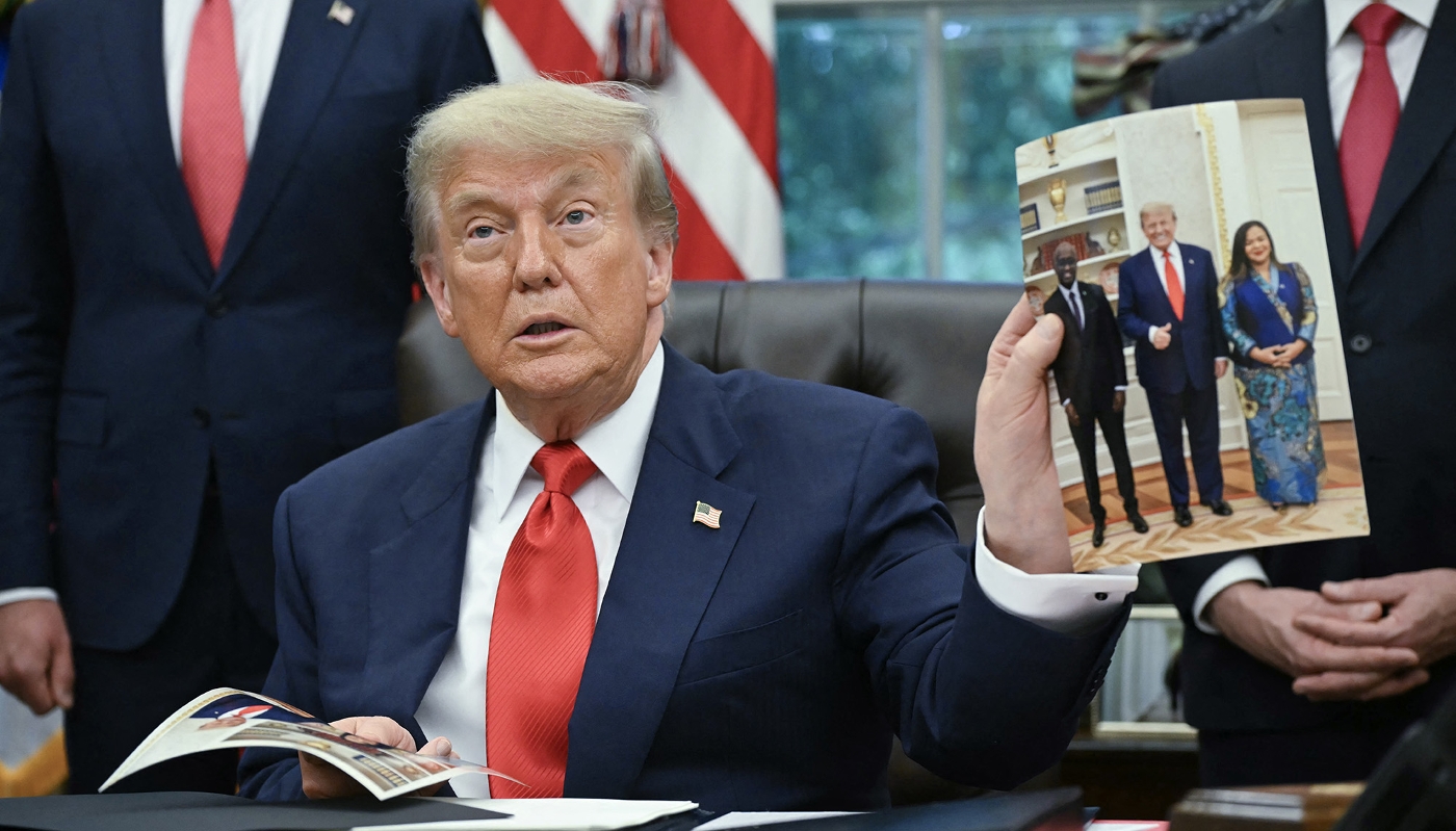 Donald Trump montre sa photo entouré des ministres des affaires étrangères du Rwanda et de la RDC, à Washington, le 27 juin 2025.