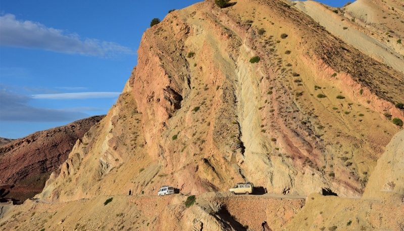 Des véhicules se frayent un chemin sur une route étroite menant au village de Tighza, au Maroc.